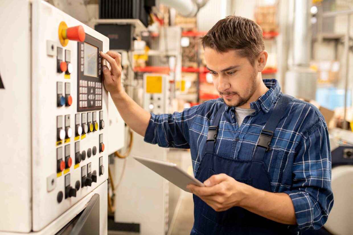 Verfahrensmechaniker für Kunststoff- und Kautschuktechnik arbeitet an einer Maschine.